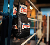Boxing gloves hanging on ropes of boxing ring